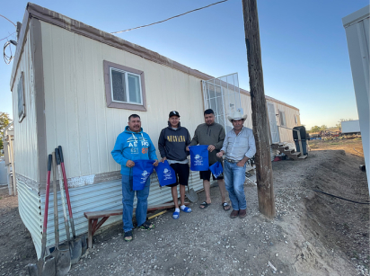 Farmworkers outside of a worksite trailer